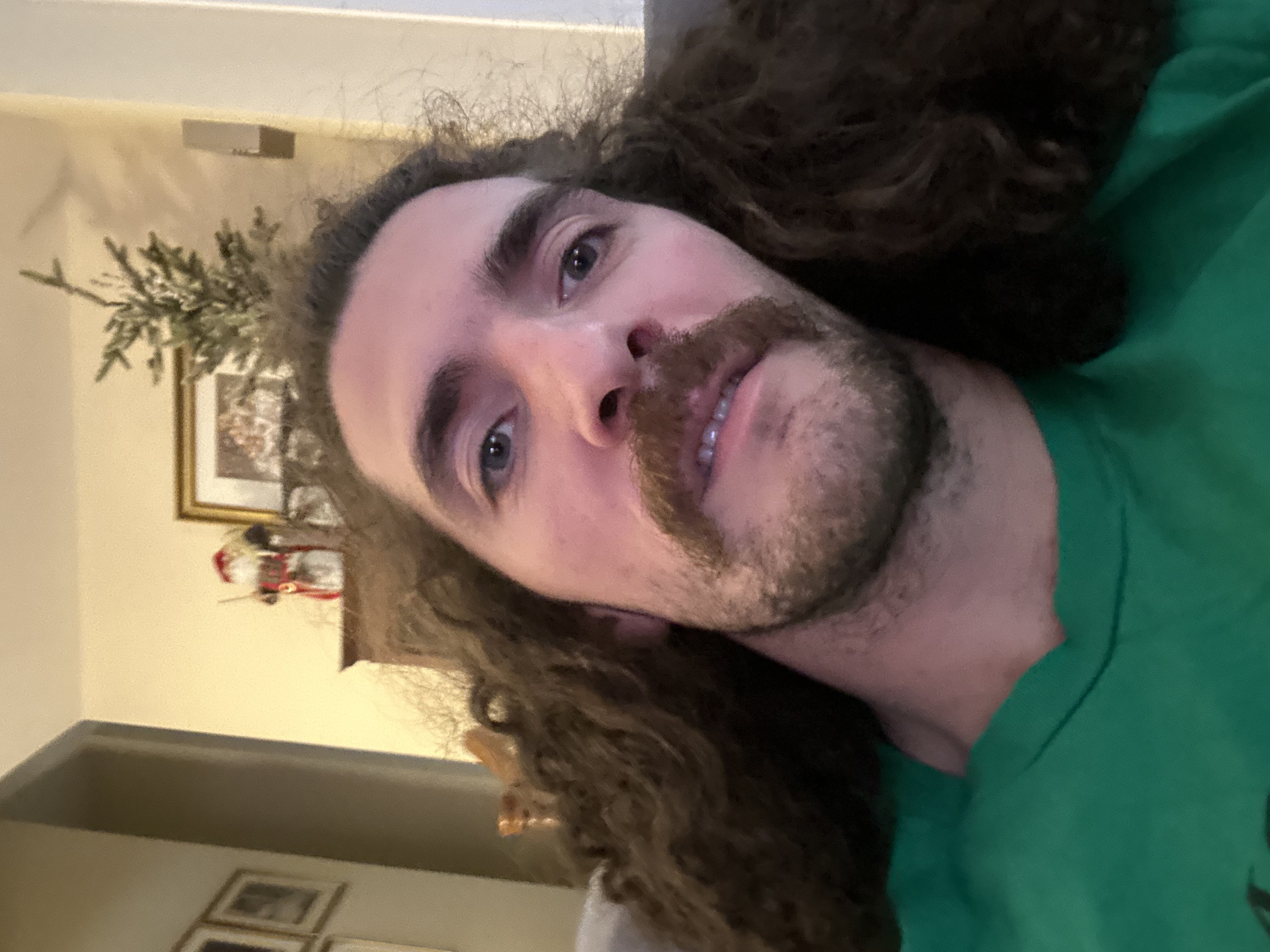 A self-portrait of a man with long curly hair and a mustache.